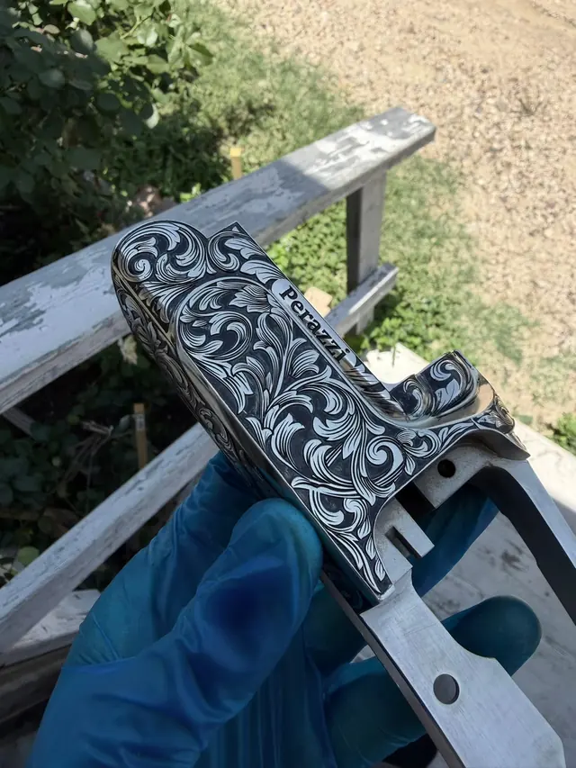 Engraved shotgun receiver with dense floral scroll pattern