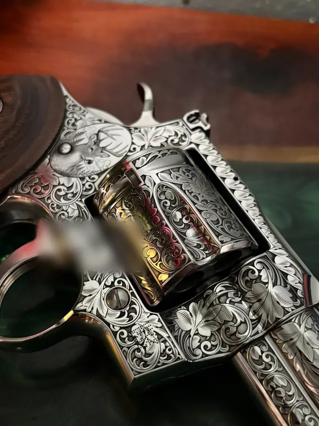 Engraved revolver cylinder frame with a deer scene and scroll border