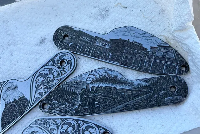 Loose engraved plates with a Western town scene, a train scene, and an eagle