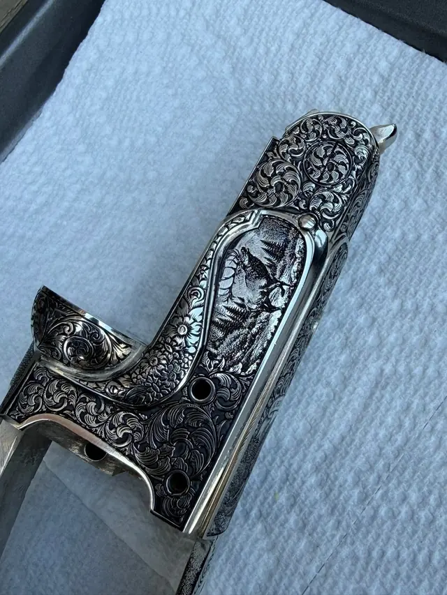 Engraved grip frame with a mountain and deer relief scene