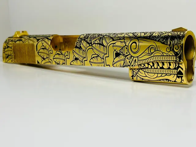 Gold pistol slide engraved with a Mesoamerican relief design
